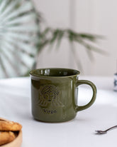 Elegant green Virgo zodiac mug with a detailed gold emblem, perfect for astrology enthusiasts, presented on a white surface with a soft background.
