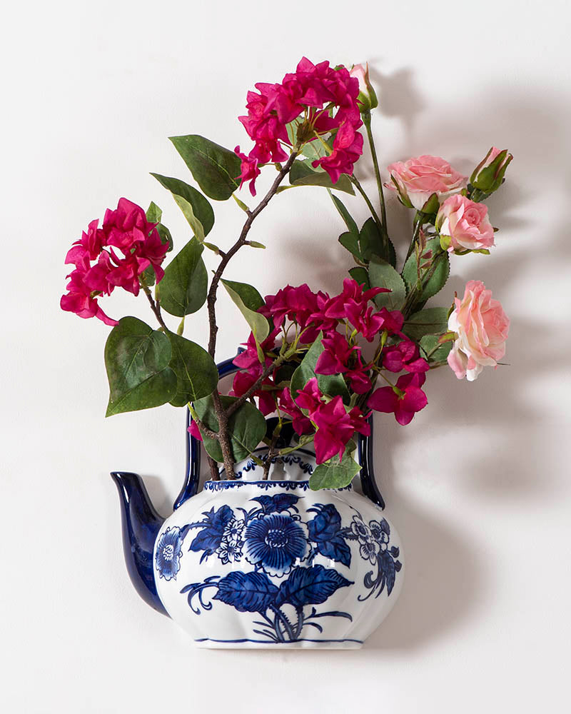 Decorative blue floral wall planter in porcelain kettle shape, ideal for indoor plants and vintage home aesthetics.