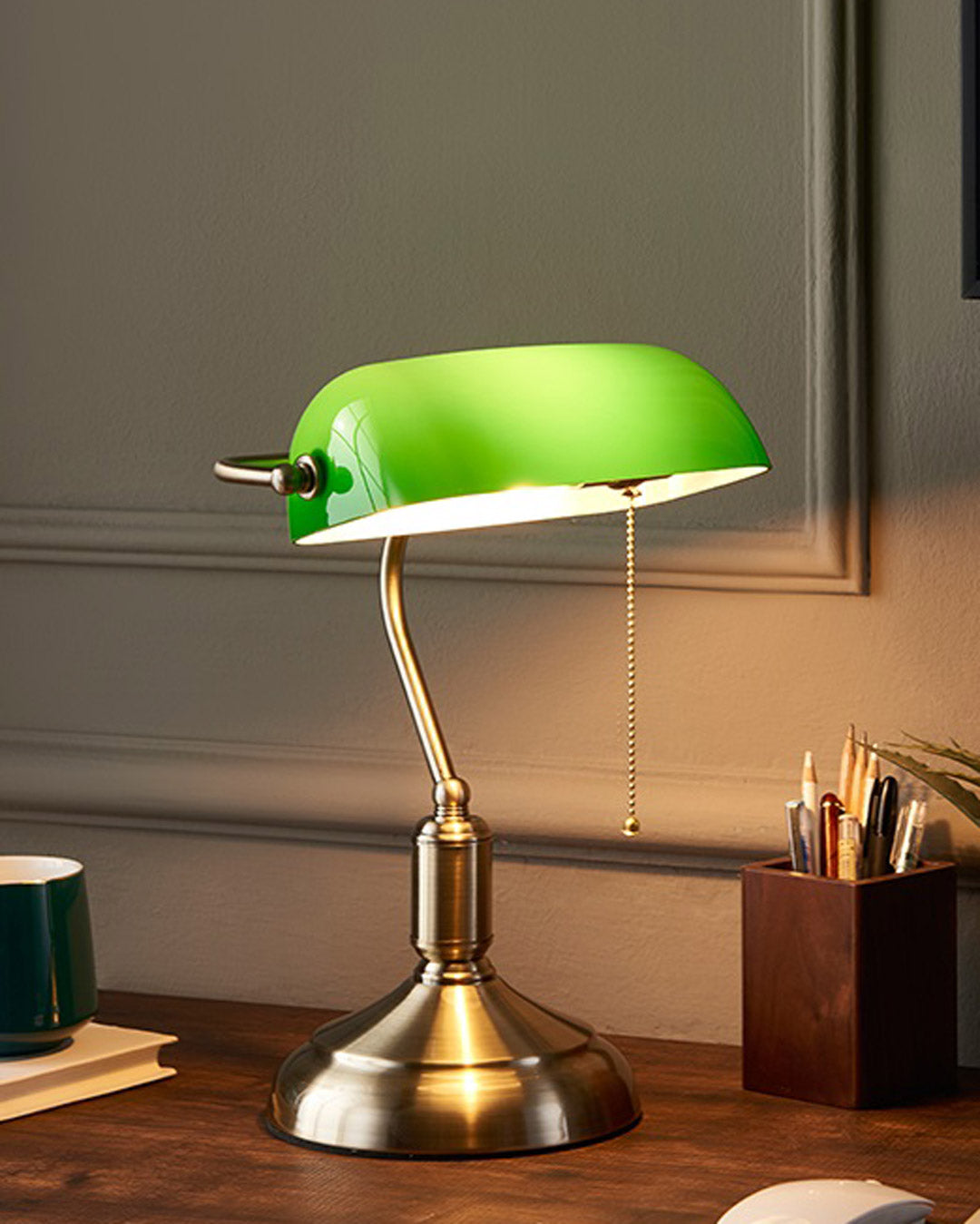 Elegant Classic Banker's Lamp with green glass shade and brass base on office desk.