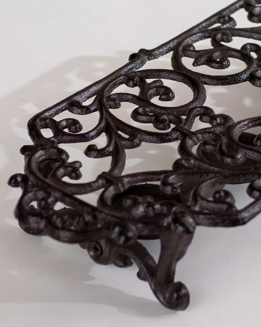 Decorative cast iron dish warmer with detailed scrollwork for a retro kitchen aesthetic. 