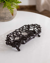 Vintage ornate cast iron trivet dish warmer, ideal for kitchen or dining table. 