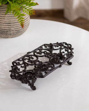 Vintage ornate cast iron trivet dish warmer, ideal for kitchen or dining table. 