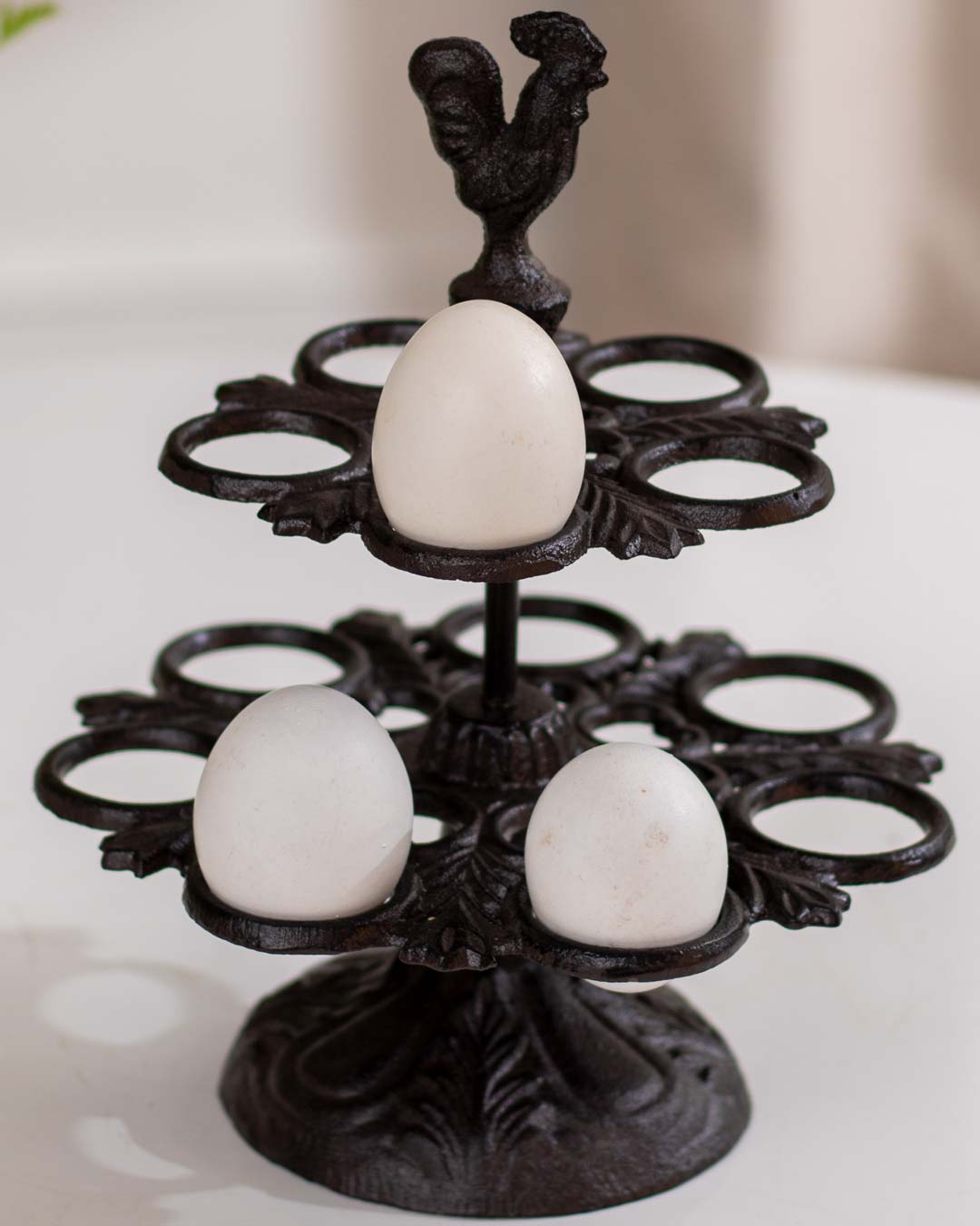 Rustic cast iron bird bath featuring sculpted birds and leaf patterns on a garden patio.