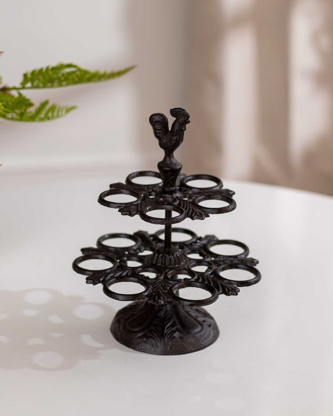 Vintage wall-mounted bird feeder in cast iron with detailed bird figures, against a wooden backdrop.