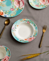 Blooming Beauty Pasta Plate featuring soft pastel floral patterns, paired with vintage gold spoon and fork, set against a grey backdrop, ideal for a spring-inspired dining experience.