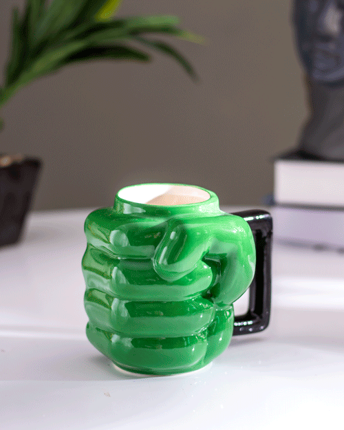 Novelty 'Mighty Green Punch' coffee mug with unique green fist design, perfect for a strong morning brew.