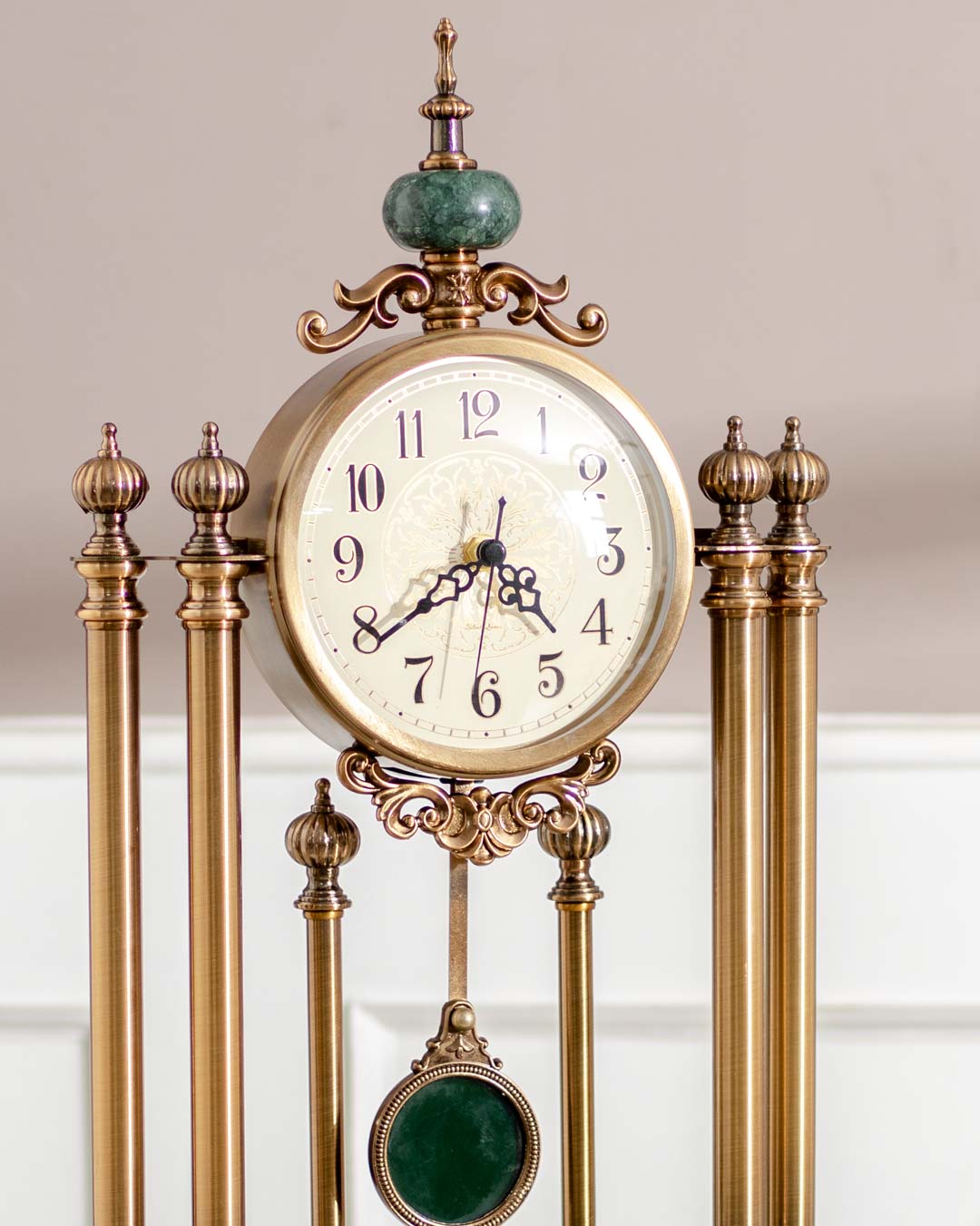 Luxurious 'Villa Vista' mantle clock with a swinging pendulum, ornamental gold pillars, and a timeless vintage design. 