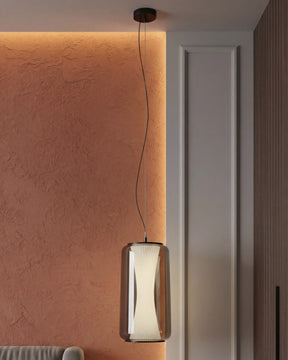 Modern pendant light hanging against a textured wall with a neutral door in the background. 