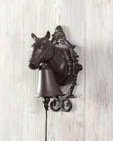Rustic cast iron horse-head bell, wall-mounted with a vintage appeal.