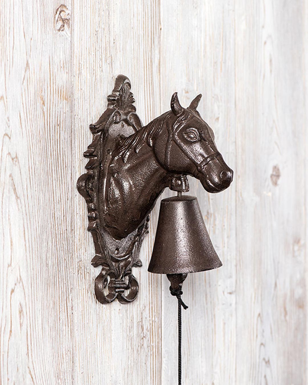 Ornate horse design on cast iron wall bell