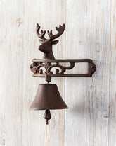 Rustic cast iron bell with reindeer topper, wall-mounted for vintage-inspired home decor.