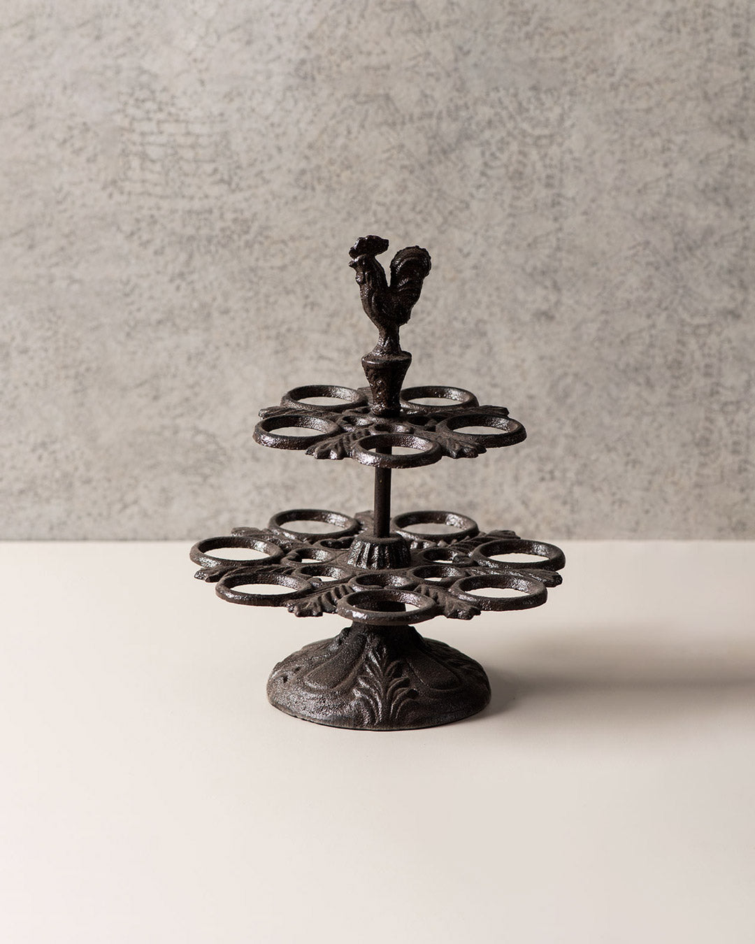 Vintage cast iron egg display stand featuring a rooster figure and multiple egg holders.