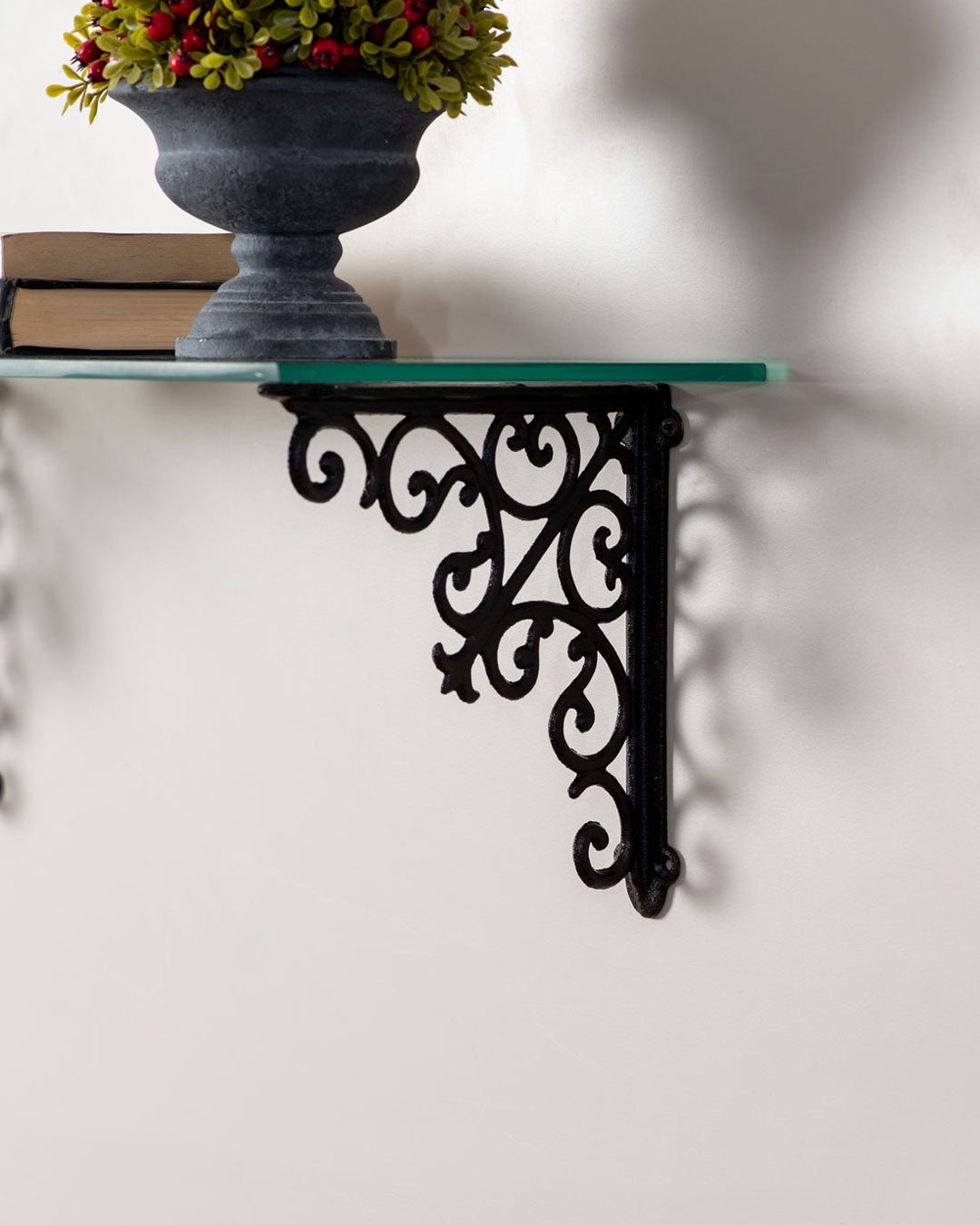 Elegant wall-mounted ornate cast iron shelf with intricate scrollwork for chic home decor.